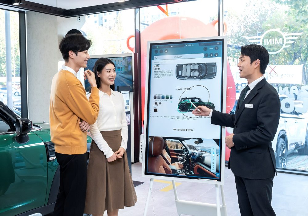 MINI 영업직원이 삼성 전자칠판 ‘플립2’를 활용해 방문객에게 차량을 소개하고 있다.