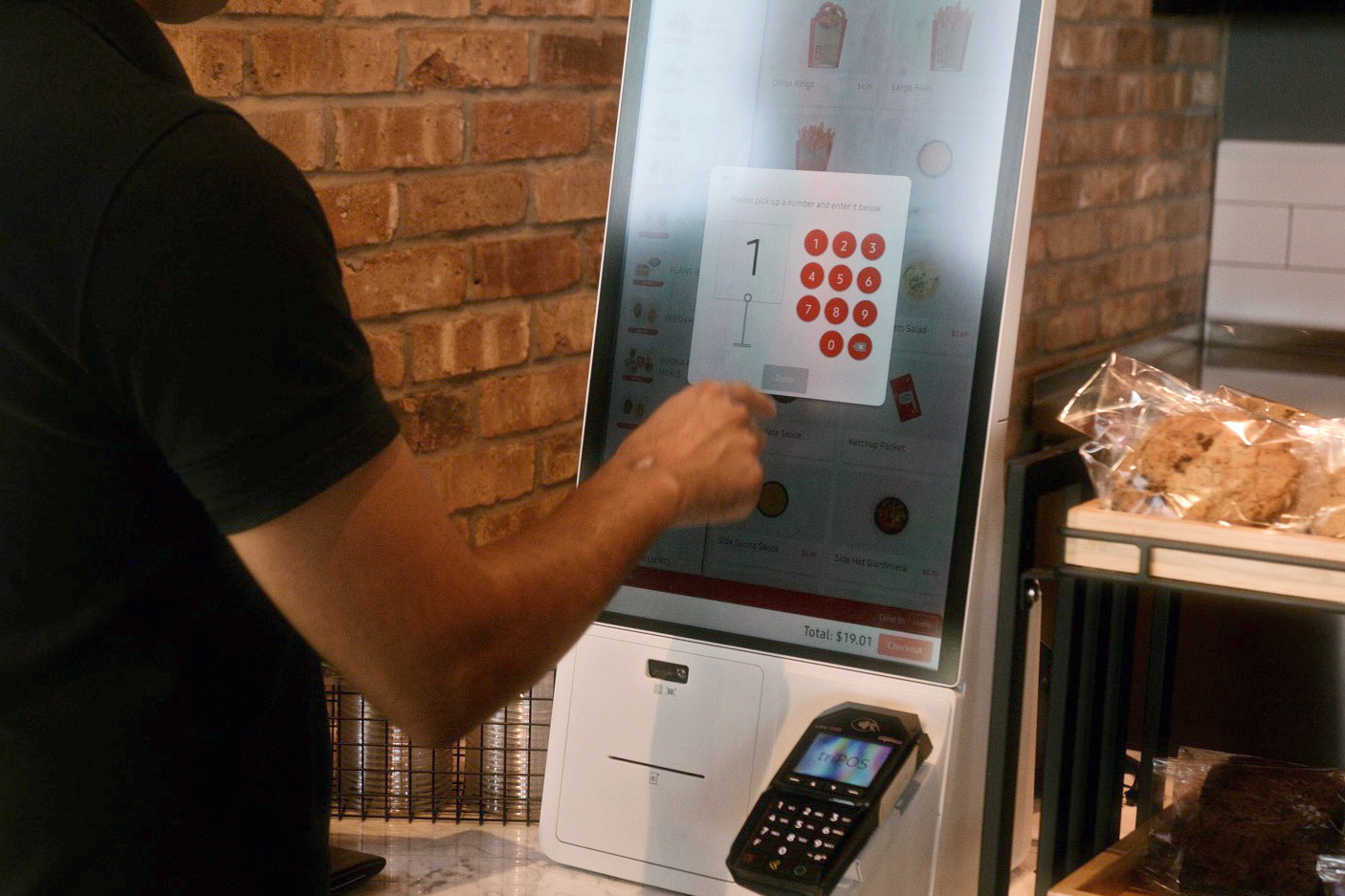 Person making an order through Samsung kiosk at Buona Beef restaurant